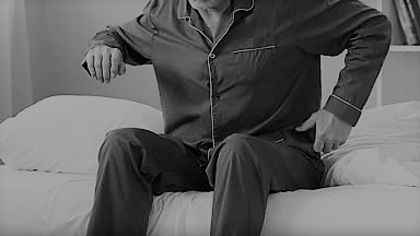 elderly-man-sitting-on-bed